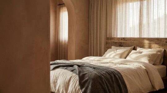 Dormitorio sereno con textiles naturales y luz suave que muestra el contraste entre fibras orgánicas y sintéticas